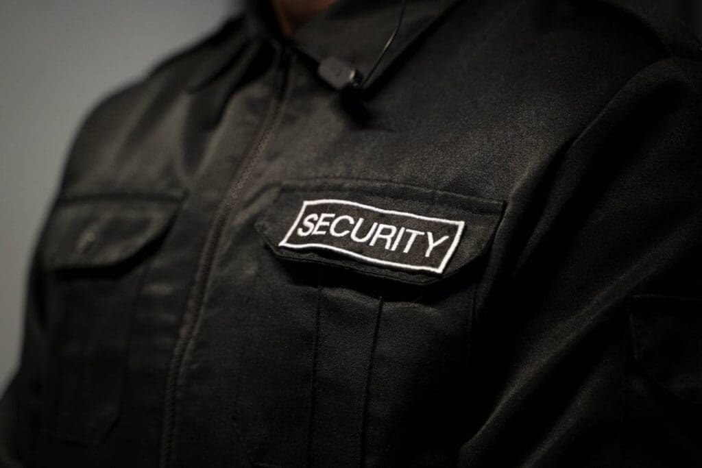 Nahaufnahme einer Sicherheitsuniform mit einem gestickten "Security"-Abzeichen.